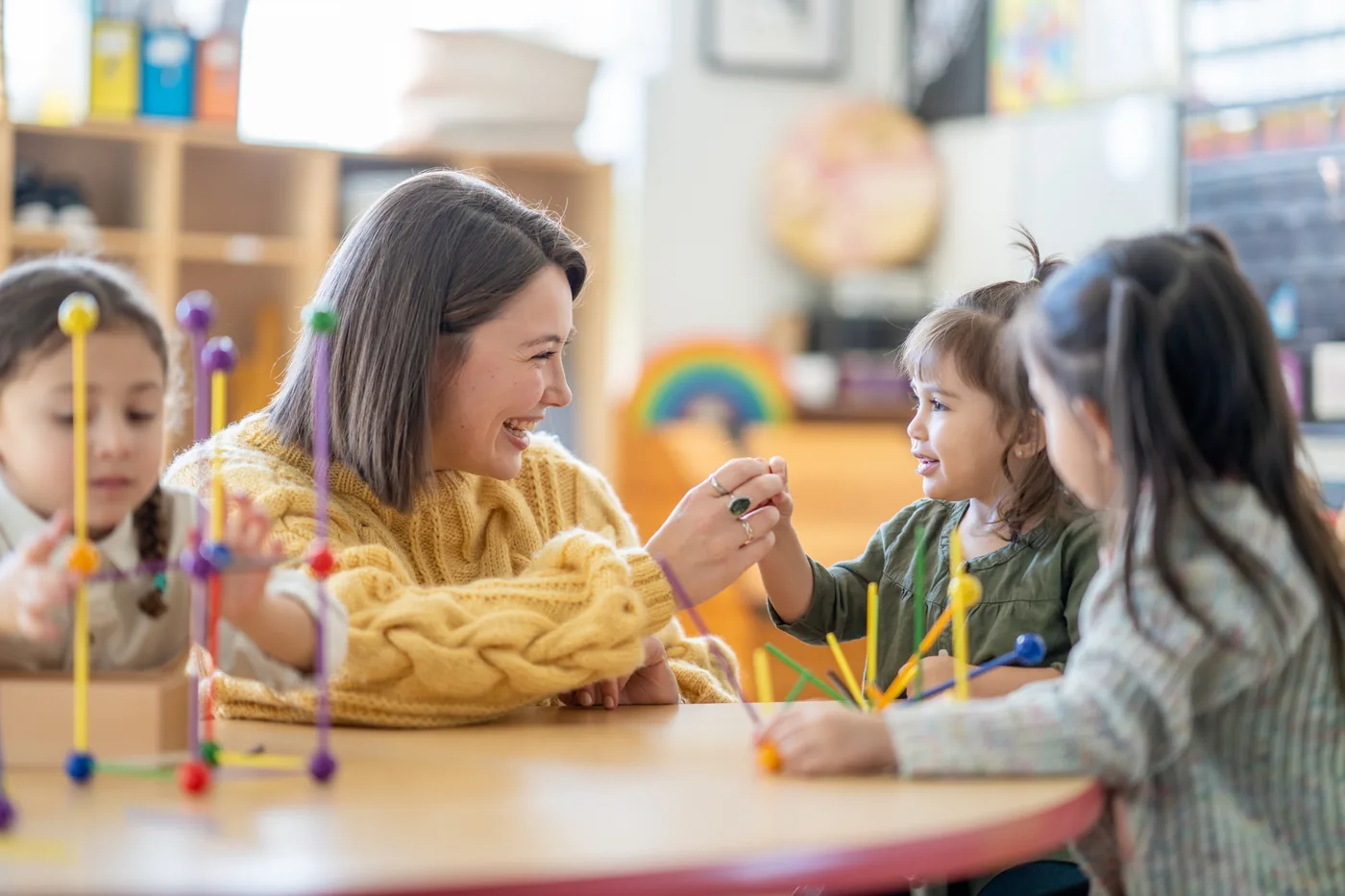 An educator and preschool children playing together