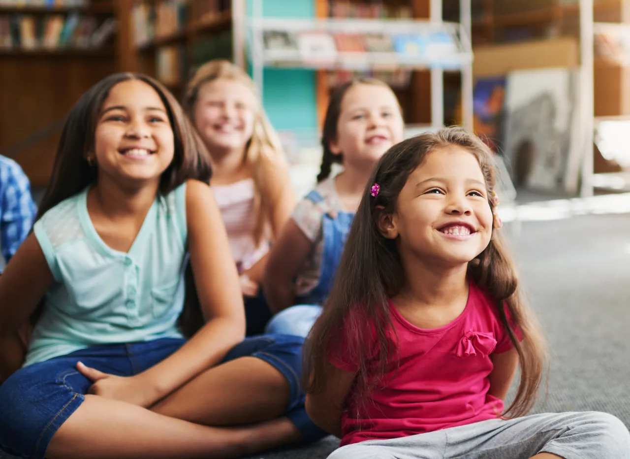 Smiling children sitting together on a classroom carpet